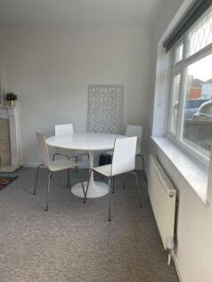 A bright and tidy living room with a modern din...