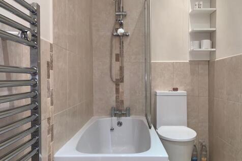 Well-maintained bathroom suite featuring a mode...