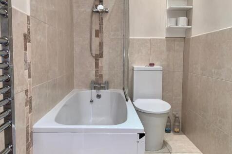 A modern bathroom featuring a clean white batht...