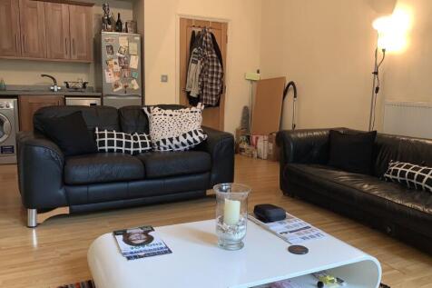 A cozy living room featuring two black leather ...