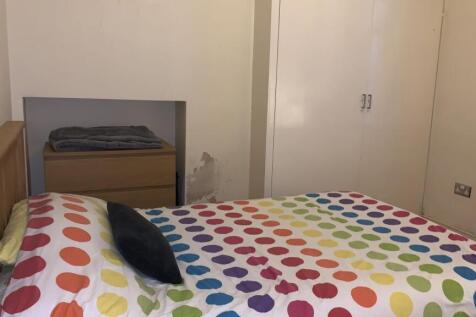 A cozy double bedroom featuring a colorful polk...