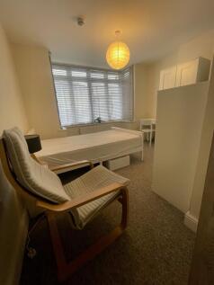 A cozy single bedroom featuring a comfortable c...