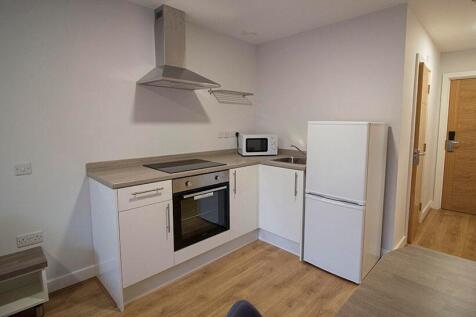 A modern, clean kitchen featuring white cabinet...