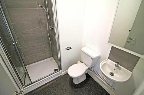 A modern bathroom featuring a glass-enclosed sh...