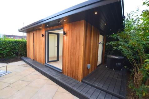 A modern property exterior featuring warm timbe...