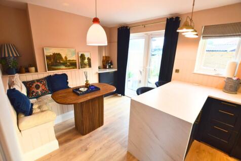 A modern kitchen featuring a cozy built-in benc...