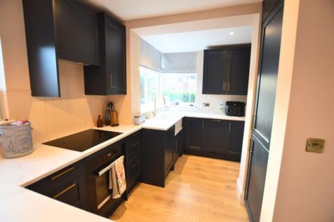 Modern kitchen featuring sleek dark cabinetry c...
