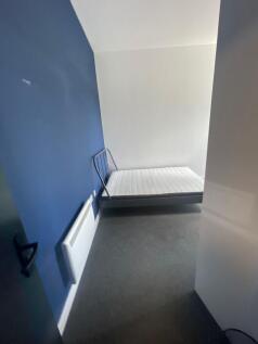 A simple bedroom featuring a clean white mattre...
