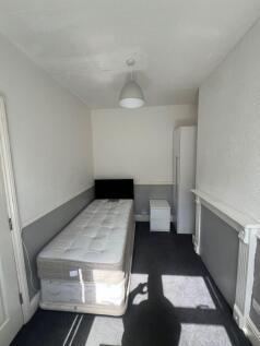 A bright single bedroom featuring a comfortable...