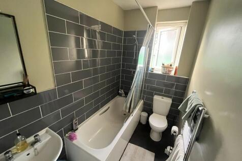 Well-maintained bathroom featuring a white bath...
