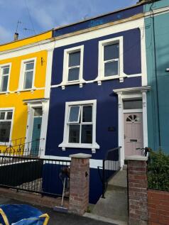 Vibrantly painted terraced houses with bold yel...