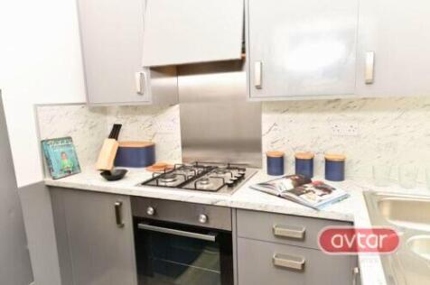 A modern kitchen featuring sleek grey cabinetry...