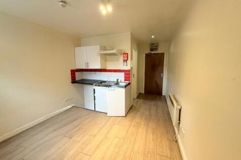 Compact kitchen area featuring modern white cab...