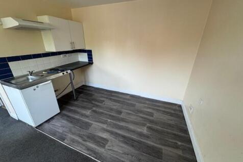 A compact kitchen area featuring basic white ca...