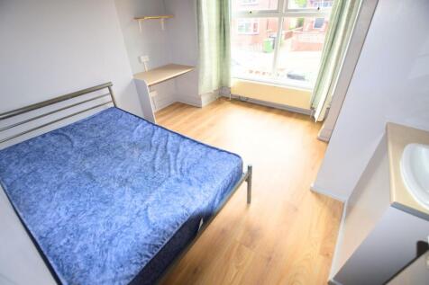 A bright double bedroom featuring a large windo...