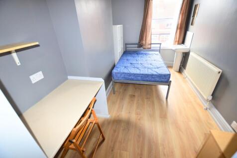 A bright single bedroom with light wooden floor...