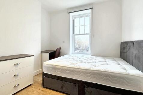This inviting double bedroom features a comfort...