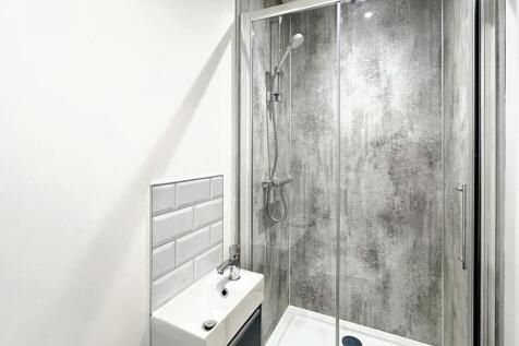 Modern bathroom featuring a sleek glass shower,...