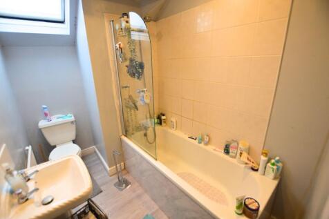 Bright bathroom suite featuring a clean bathtub...