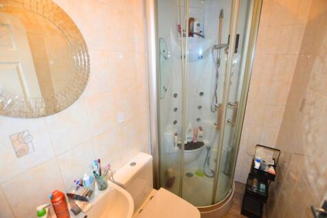 Bright bathroom featuring a modern enclosed sho...