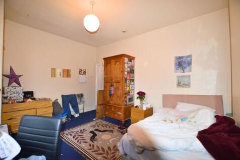 A cozy single bedroom featuring a comfortable b...