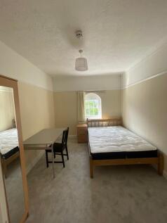 A bright and tidy double bedroom featuring a co...