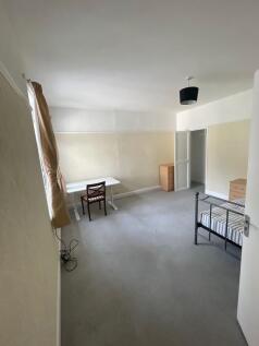 A bright and tidy single bedroom featuring a me...