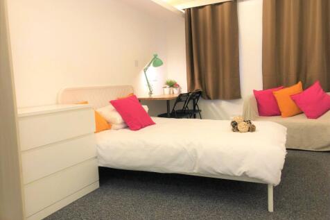 A cozy single bedroom featuring a comfortable b...