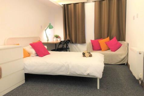 A cozy single bedroom featuring a neatly made b...