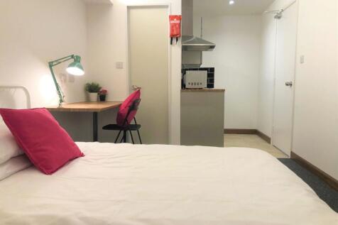 A neat and cozy single bedroom featuring a comf...