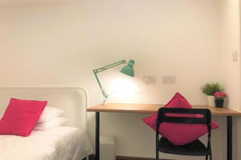 A tidy and cozy single bedroom featuring a whit...