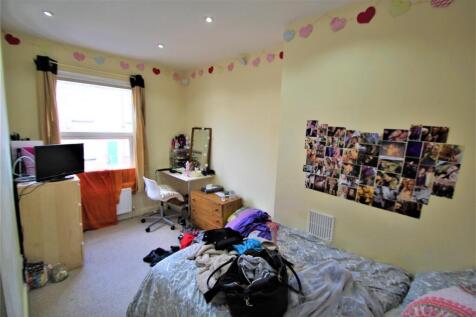 Cozy single bedroom featuring a large window wi...