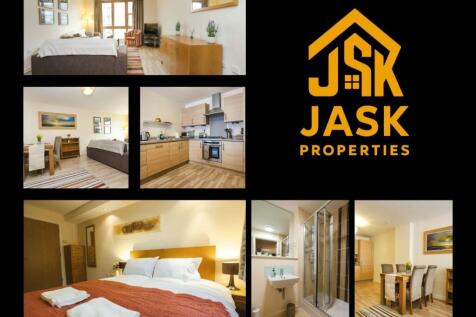 A bright and spacious master bedroom with a com...