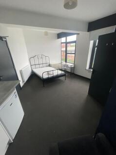 Bright double bedroom featuring large windows t...