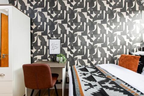 A stylish double bedroom featuring a bold patte...