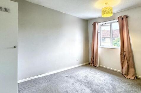 A bright double bedroom featuring a large windo...
