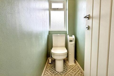 A bright and clean single toilet room featuring...