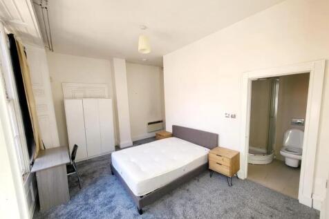 Bright and spacious master bedroom with a comfo...