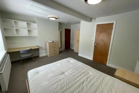A bright double bedroom featuring a comfortable...