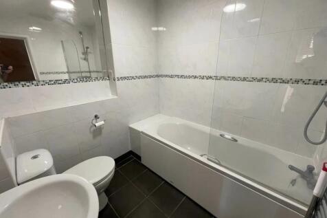 A modern bathroom suite featuring a clean white...