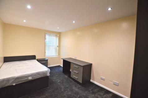 A neat and well-lit single bedroom featuring a ...