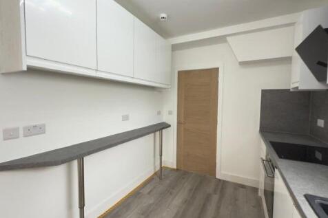 Modern kitchen with sleek white cabinets and da...