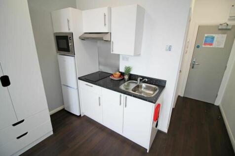 Bright, modern kitchen area with clean white ca...