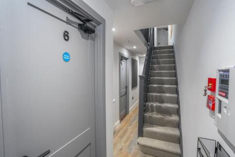 A clean and modern hallway with grey doors and ...