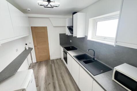 Bright and modern kitchen featuring sleek white...