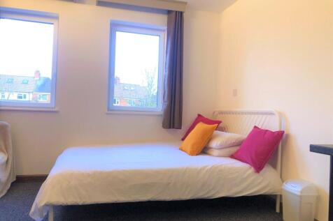 A cozy single bedroom with a neatly made bed ad...