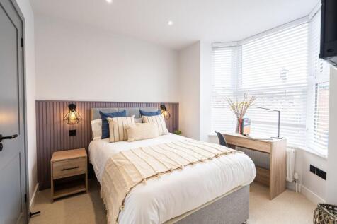 A bright and inviting master bedroom featuring ...