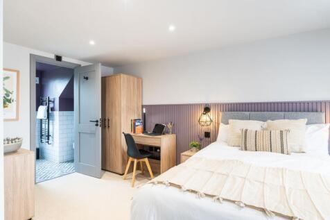 Bright and modern master bedroom featuring a co...