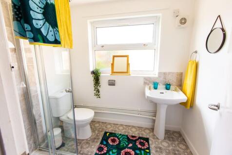 A clean and bright bathroom featuring a shower,...