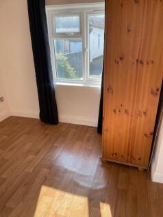 A cozy single bedroom featuring a bright window...